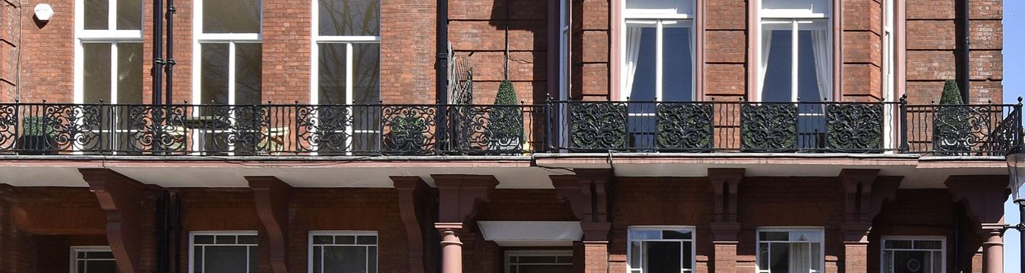The frontage of a traditional red brick apartment block