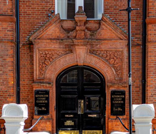 The entrance of a red brick apartment building in Kensington