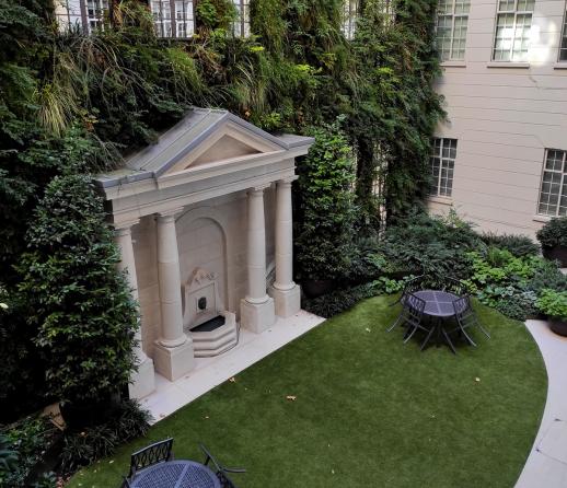 The courtyard of an apartment building in London with bistro tables and chairs